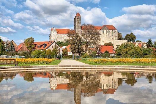 Schloss und Kirche in Quedlinburg, umgeben von B&auml;umen.