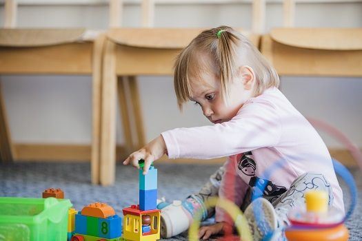 Kleines M&auml;dchen spielt mit Legosteinen.