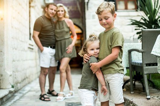 Gl&uuml;ckliche Familie, die sich umarmt und vor sich hinschaut.