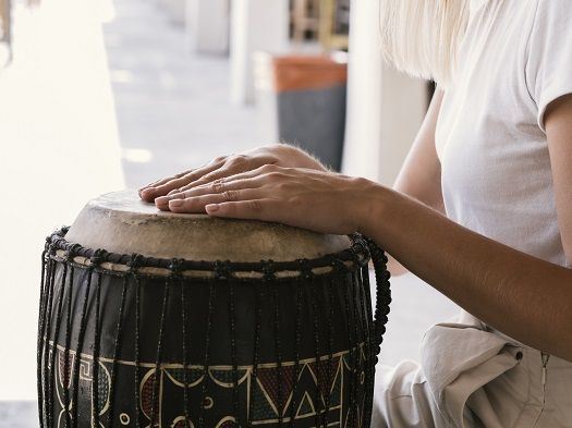 Junge Frau, die eine Trommel spielt.