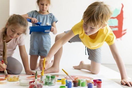 Kinder halten Pinsel in ihren Händen und malen.