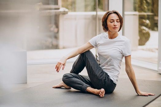 Junge Frau praktiziert Yoga in einem Raum.
