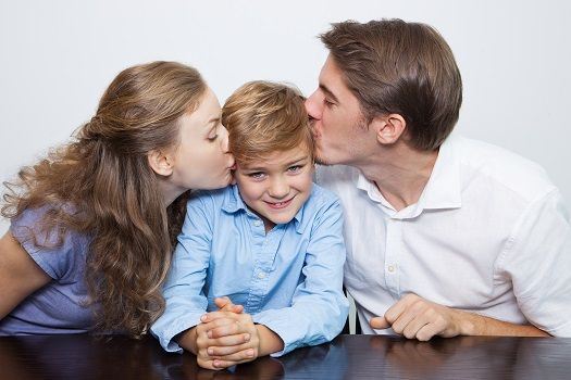 Mutter und Vater posieren mit ihrem Sohn für ein Foto.