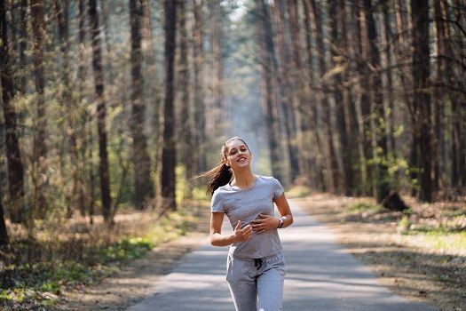 Junge sportliche Frau spaziert im Wald.